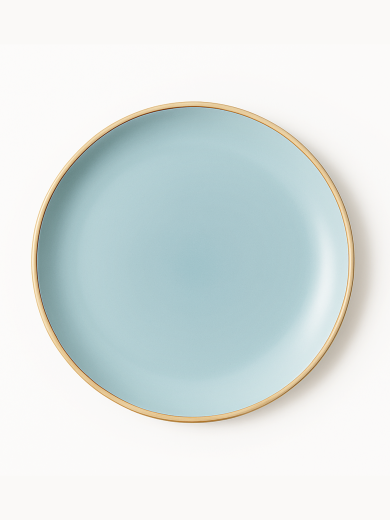A top-down view of a round ceramic plate featuring a smooth matte finish in light blue with a clean gold rim. The minimalist dish is centered against a solid white background.