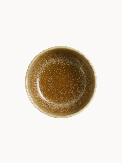 A top-down view on a round ceramic bowl with a glossy glaze featuring an earthy brown color dripping down into a textured, light beige and grey finish, on a plain white background.
