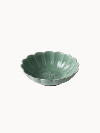 A small, sage green ceramic bowl designed in the shape of a blooming flower,  finished with a smooth glossy glaze, isolated on a plain white background.
